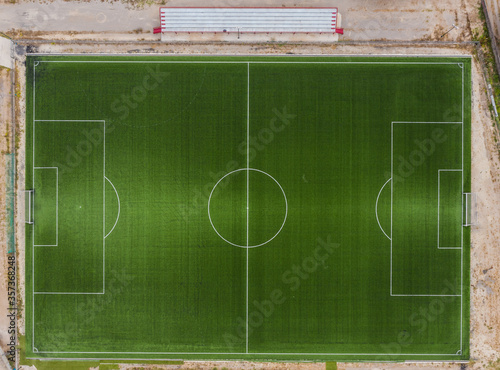 Top down drone view of a football field on the outskirts of a village