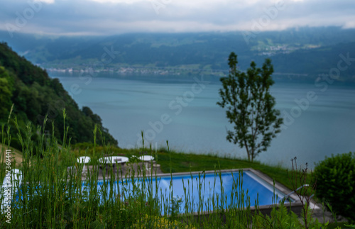 View of Lake Lucerne near Gersau town. Swiss Alps in the background. Canton of Schwyz, Switzerland. Hilltop pool.