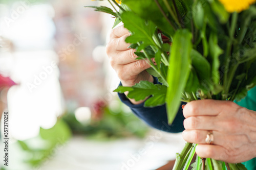 The work of the florist. Flower packaging. Creating a flower bouquet. Roses in a package. The hands of the florist. Selective focus. 