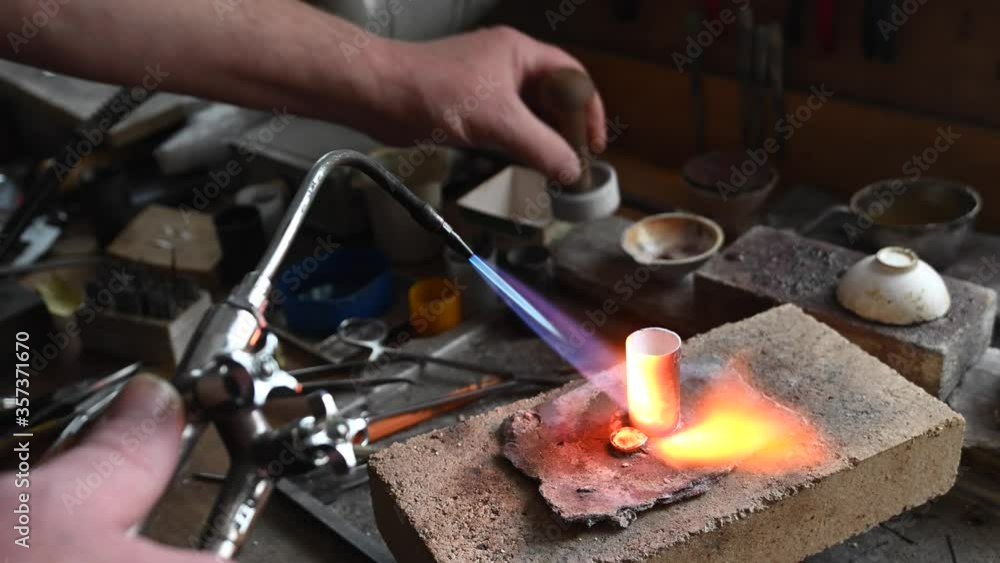 Caucasian person melts gold in liquid state in crucible. Craft luxury jewelery Caucasian person melts gold in liquid state in crucible. Craft luxury jewelery
