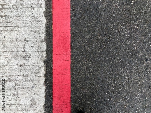 red line on the black rough asphalt road