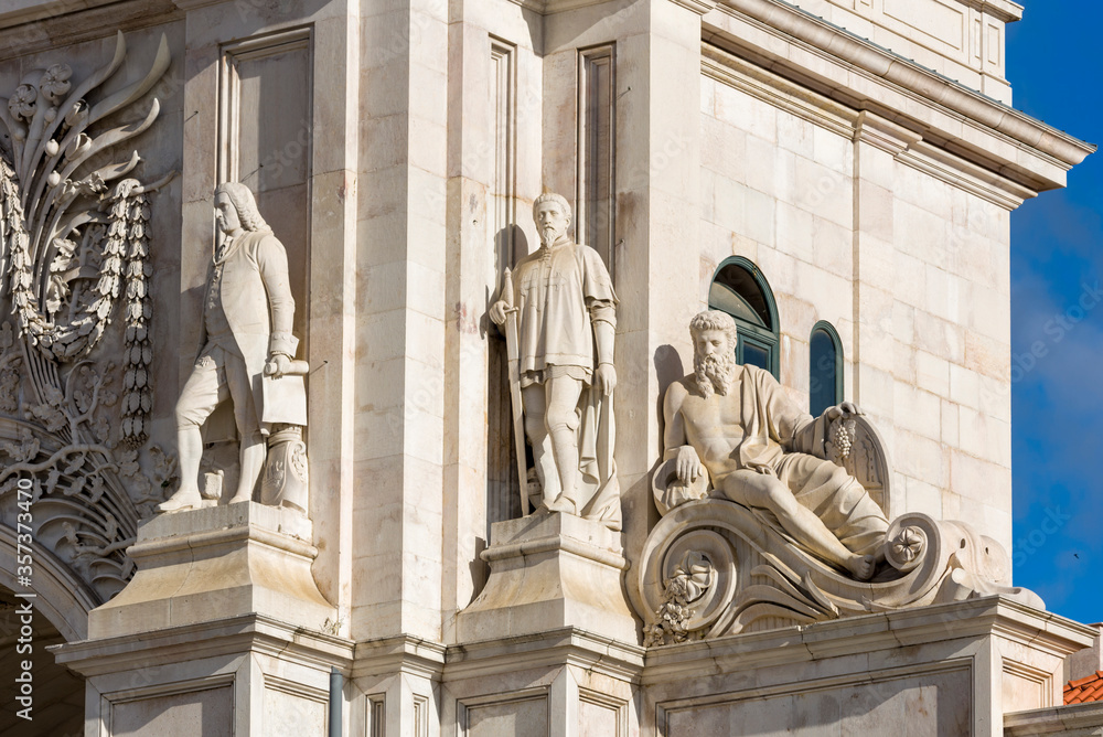 Obraz premium two seated statues at the base of Arco da Rua Augusta in Lisbon