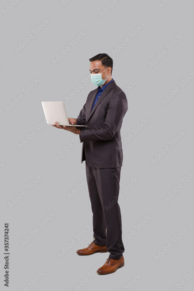 Businessman Using Laptop Green Screen Isolated Wearing Medical Mask. Indian Business man with Laptop in Hands. Online Business Concept Businessman Using Laptop Green Screen Isolated Wearing Medical Mask. Indian Business man with Laptop in Hands. Online Business Concept