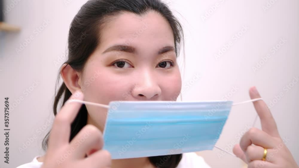 Beautiful Asian woman wearing a mask look camera and relaxing stay on the bed at home lifestyle and pleasure concept. Beautiful Asian woman wearing a mask look camera and relaxing stay on the bed at home lifestyle and pleasure concept.