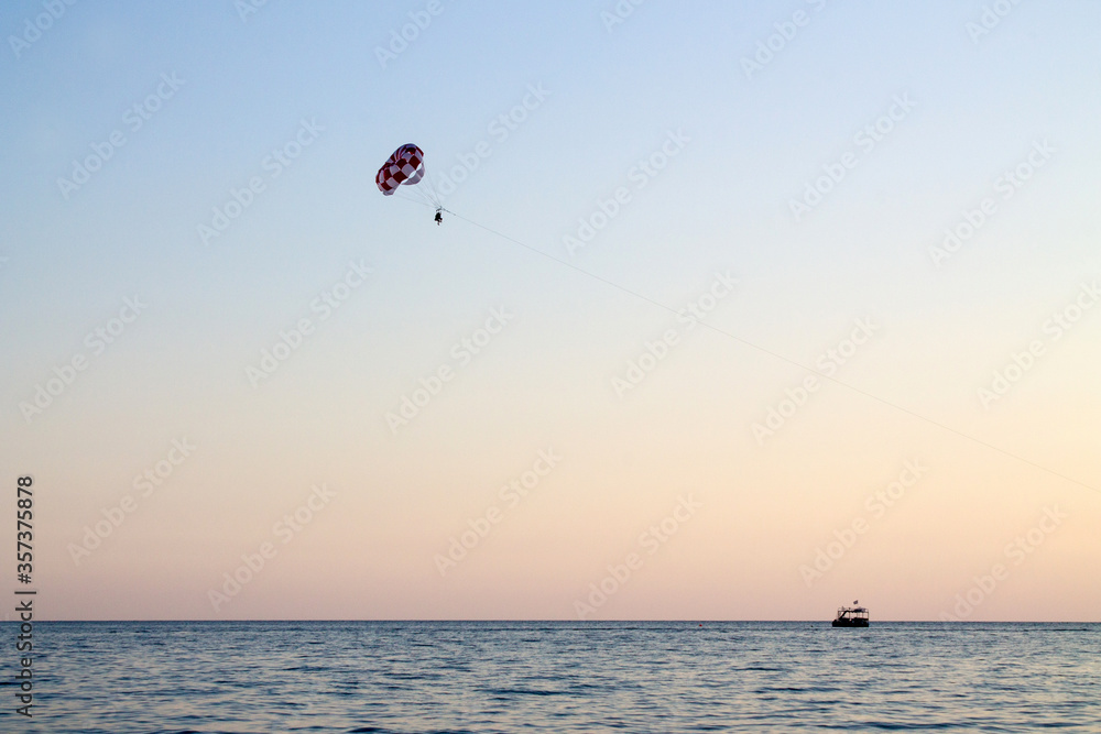 Paraglider soaring over the seashore Paraglider soaring over the seashore
