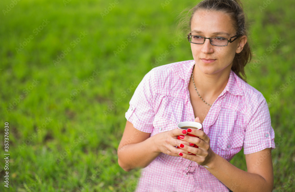 Woman holding a cup of coffee outside. Woman holding a cup of coffee outside.