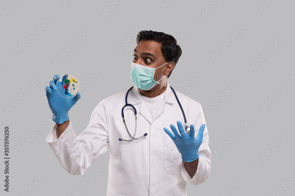 Indian Man Doctor Surprised of Petri Dish Wearing Medical Mask and Gloves Isolated. Medicine, Science Concept Indian Man Doctor Surprised of Petri Dish Wearing Medical Mask and Gloves Isolated. Medicine, Science Concept