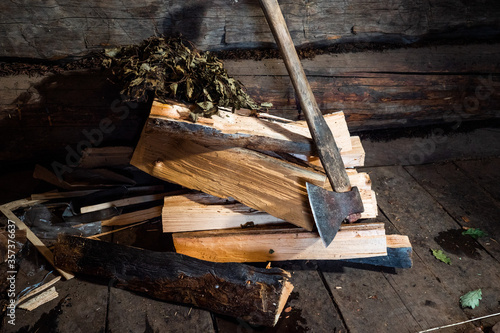 Interior of a Russian steam bath. Close up of an axe and a pile of wood.