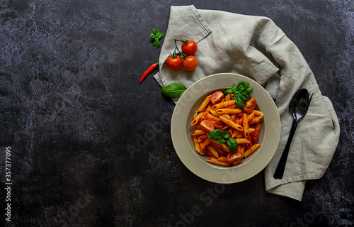 Traditional italian arrabbiata penne pasta with tomatoes, red chili peppers, garlic, basil, and cheese. Top view. copy space photo