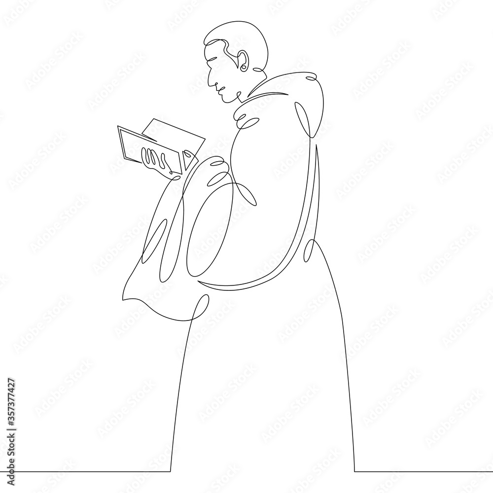 catholic monk in cassock reads bible