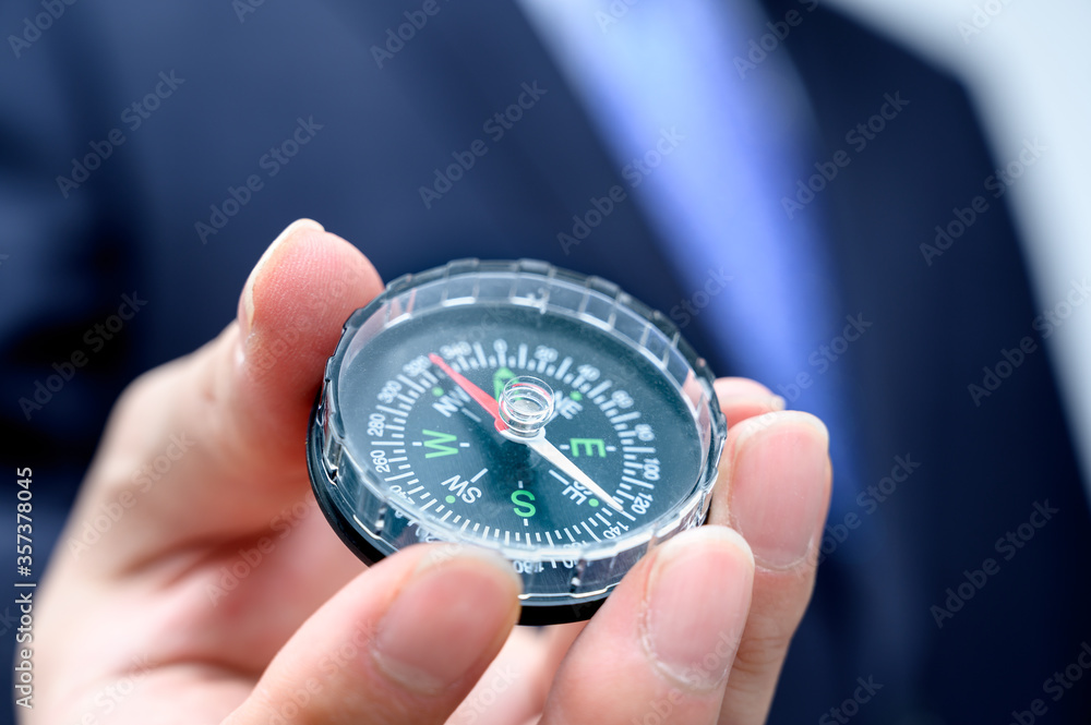 Businessman holding a compass in hand. Business concept. Businessman holding a compass in hand. Business concept.