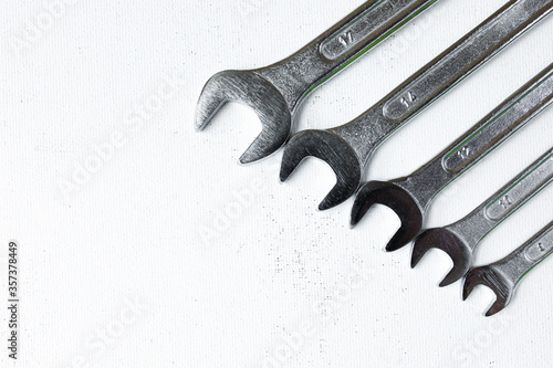 A set of silver-colored spanners for home repairs, construction work. On a scuffed white background. Flatley.