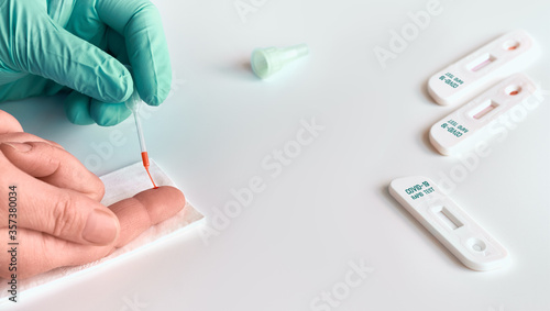 Rapid express COVID19 test for detection of specific antibodies IgM and IgG to novel corona virus SARS-CoV-2 causing Covid-19 illness. Medic or doctor applies blood from patient finger on test.