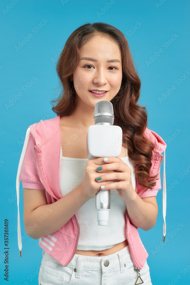 Young pretty woman happy and motivated, singing a song with a microphone, Young pretty woman happy and motivated, singing a song with a microphone,