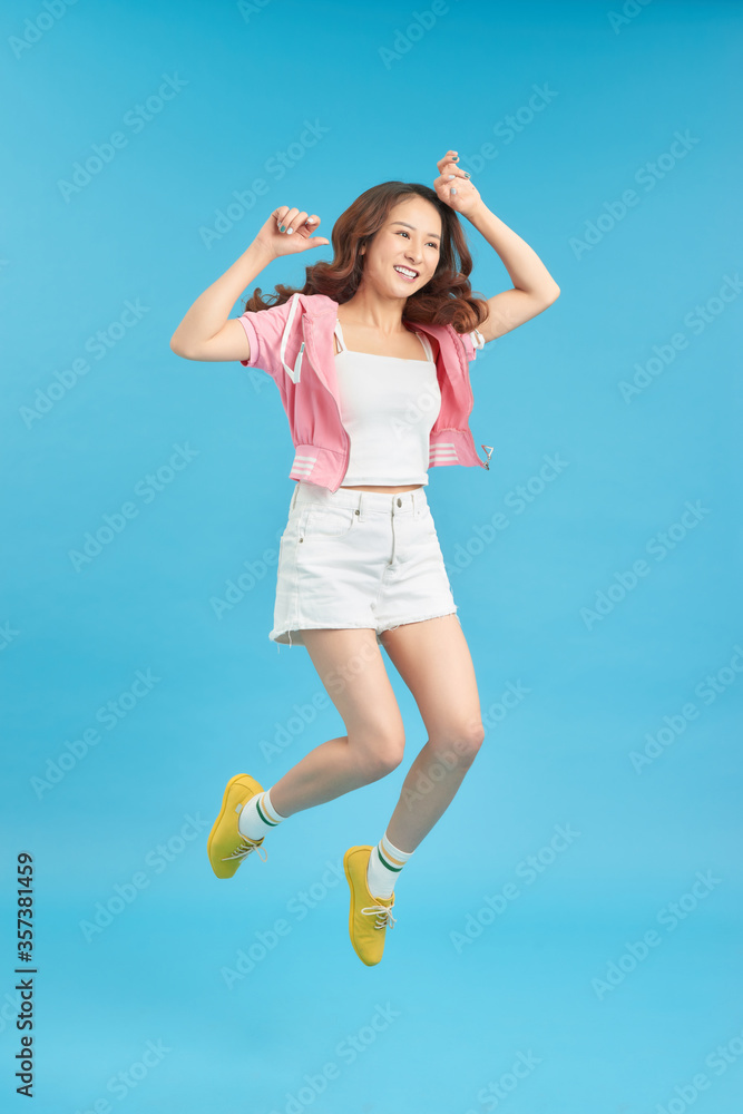 Vertical full length portrait of happy crazy woman is jumping up Vertical full length portrait of happy crazy woman is jumping up