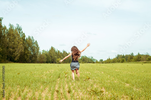 Kid girl jumping on the grass at spring.Summer field, horizon and sky. Happy childhood and freedom.Life Style Outdoors.