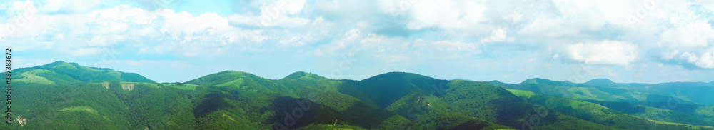 Panoramic mountain landscape. Forested mountains, cloudy, summer day