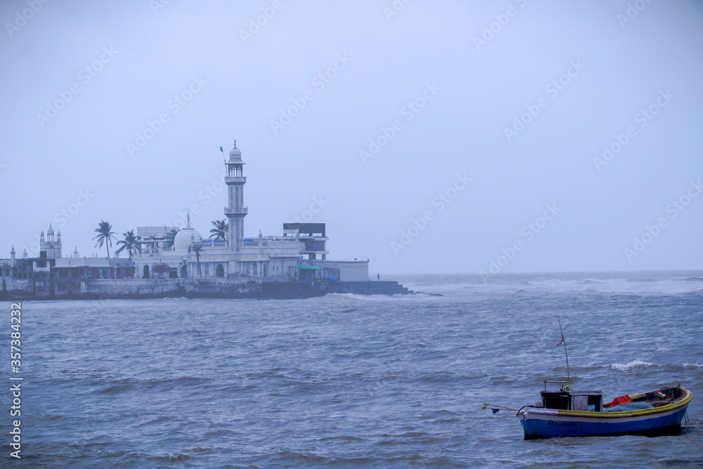 A solo boat in a arabian sea at Mumbai with Haji Ali Dargah At background.
