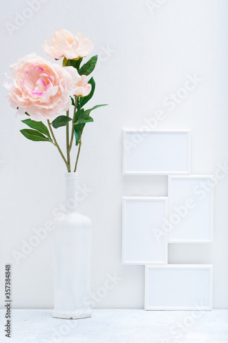 Stylish white mock up with vertical poster and plant in a vase