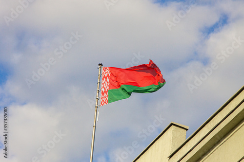 Waving flag of Belarus on the blue sky background photo