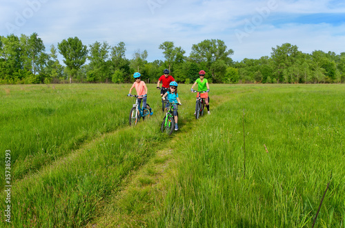 Happy family on bikes, spring cycling outdoors with kids

