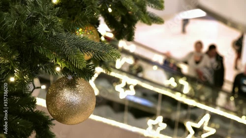 Christmas decorations in Sopping Mall. People on escalator, in festive shopping center, make New Year's purchases,.