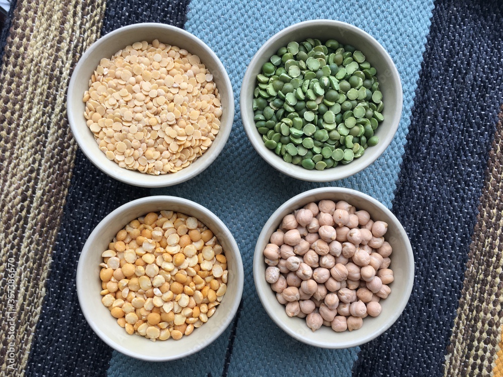 Round bowls with different legumes, peas, chickpeas and lentils on a colored tablecloth. Place for text. High quality photo Round bowls with different legumes, peas, chickpeas and lentils on a colored tablecloth. Place for text. High quality photo