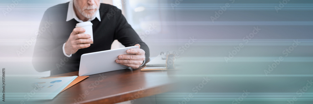 Businessman working on digital tablet at office; panoramic banner Businessman working on digital tablet at office; panoramic banner