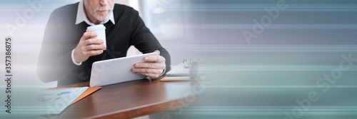 Businessman working on digital tablet at office; panoramic banner