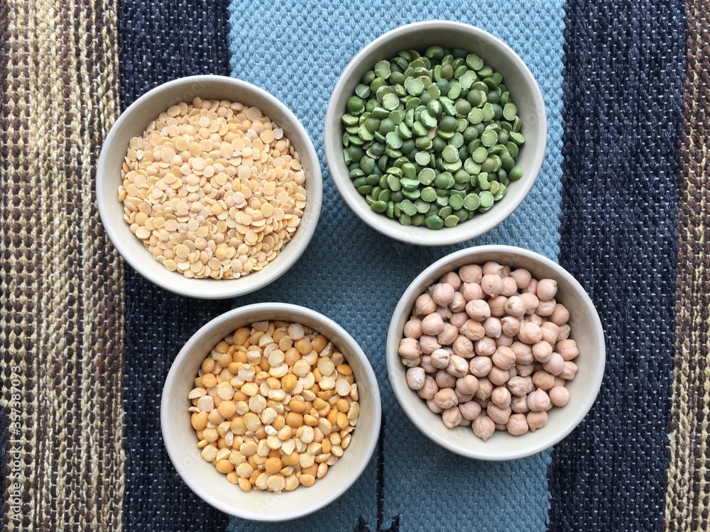 Round bowls with different legumes, peas, chickpeas and lentils on a colored tablecloth. Place for text. High quality photo Round bowls with different legumes, peas, chickpeas and lentils on a colored tablecloth. Place for text. High quality photo