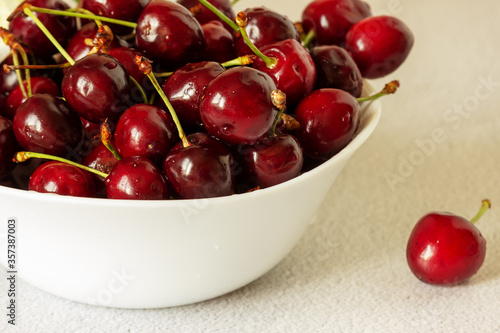 Cherry in a white plate. Close up, selective focus.