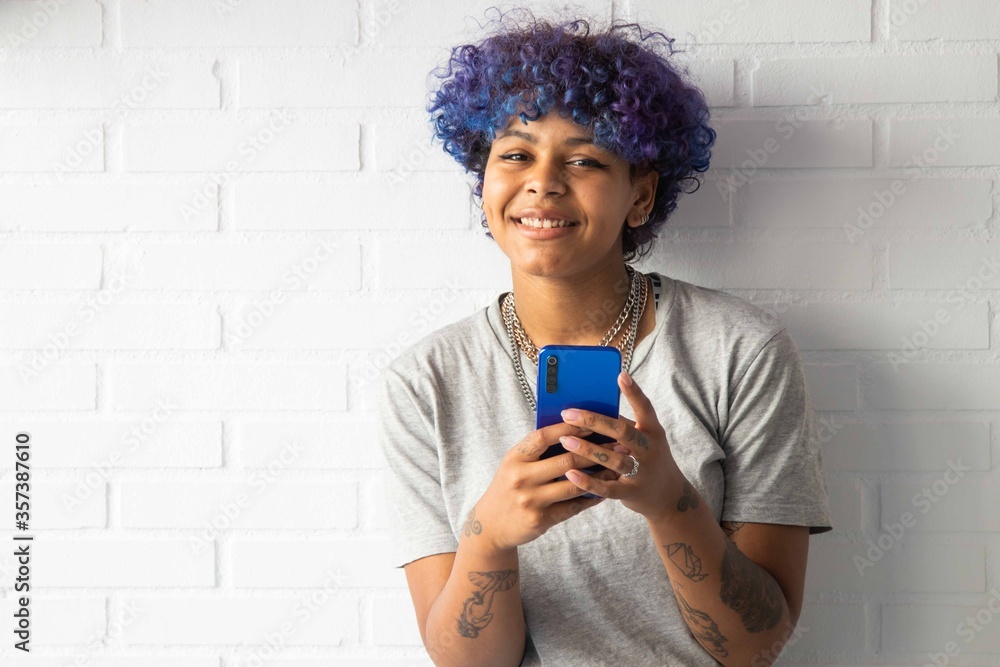 Fototapeta premium young woman afro american with smartphone on the wall