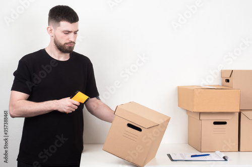 Warehouse stock. A man with a barcode reader. Marking of manufactured products. The encoding of information about the product. Marking of parcels. Reading the barcodes.
