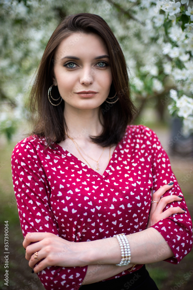 Naklejka premium young, beautiful girl posing in blooming Apple orchards
