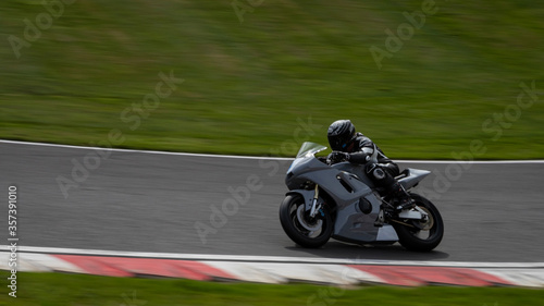 A panning shot of a grey racing bike as it circuits a track © SnapstitchPhoto