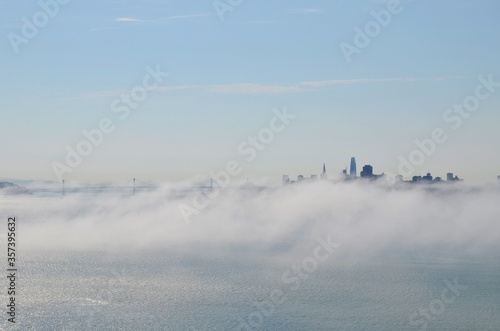 View from the top of a hill towards the city of San Francisco covered in fog , USA