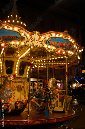 Colorful carousel at night in Paris. Authentic, vintage and historic merry-go-round in the city center.