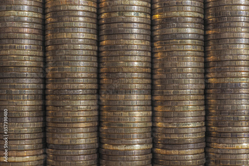 Background or wall from piles and edges of yellow brass coins close-up. 10 ten Russian rubles. Dark textured backdrop or wallpaper for economic, banking, financial topics. Aged effect shot.