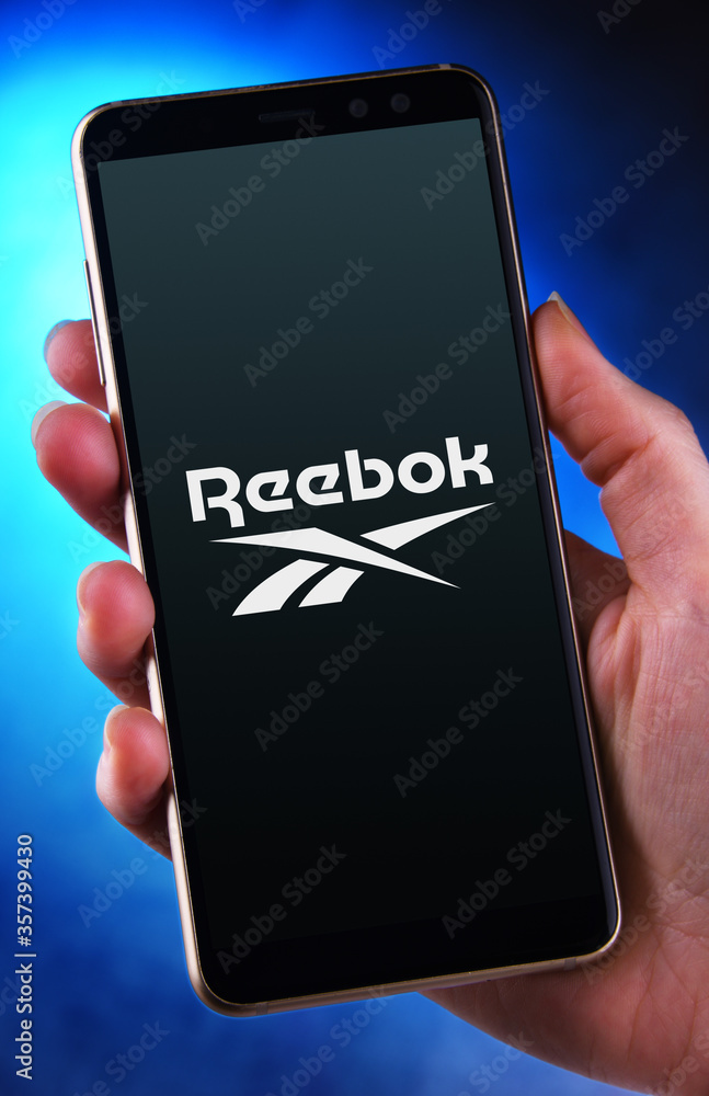 Hand holding smartphone displaying logo of Reebok foto de Stock | Adobe  Stock
