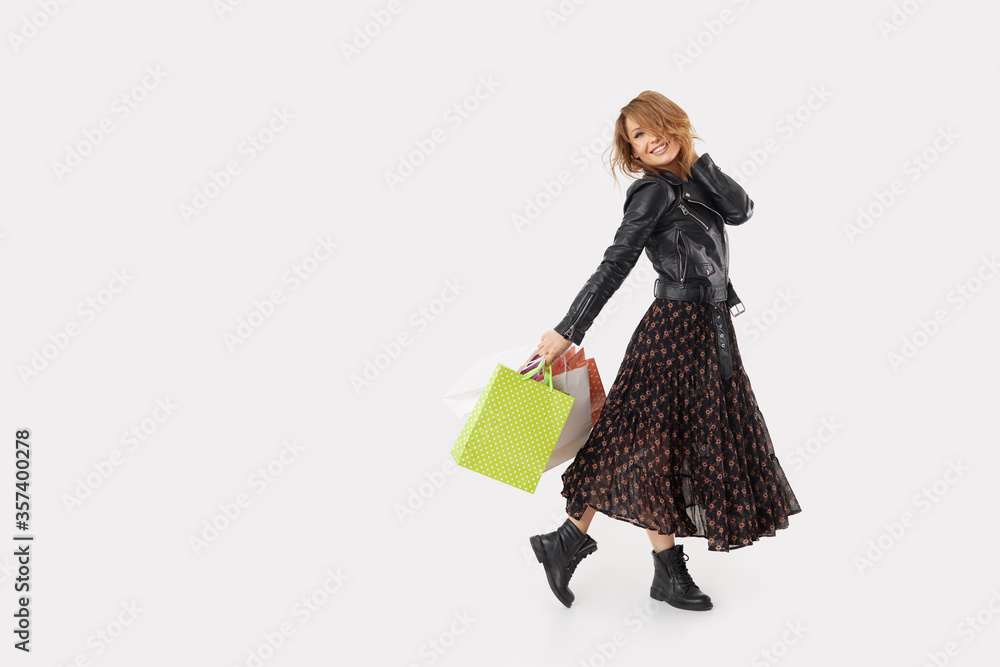 Young woman with shopping bags makes purchases through the online app on a smartphone