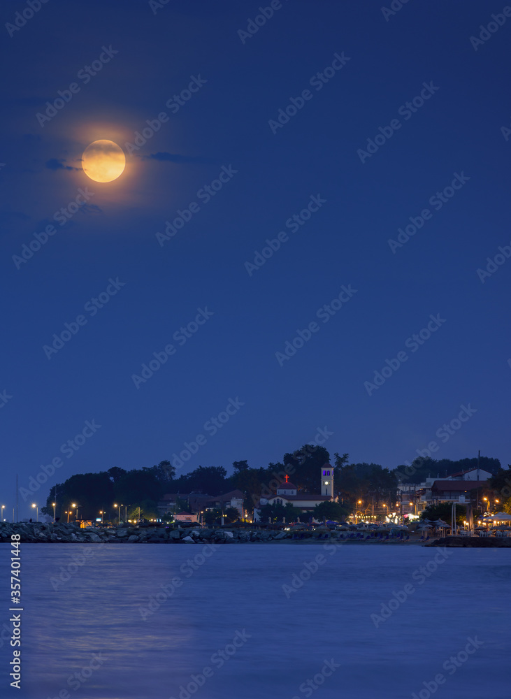 Full moon over the seaside village of Platamonas in Greece