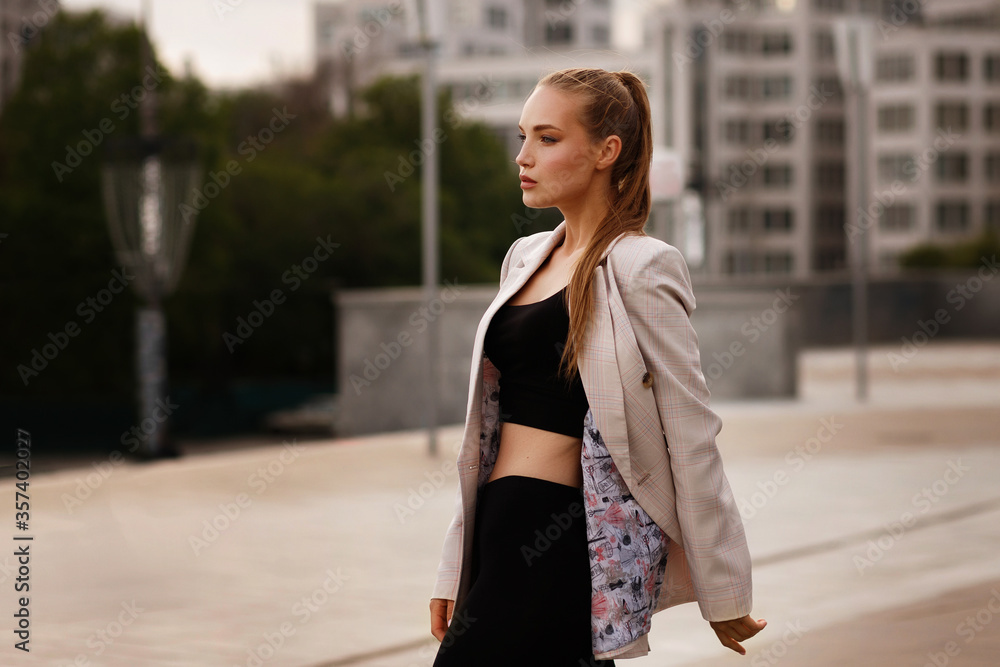 Model in a top and jacket walks around the city Model in a top and jacket walks around the city