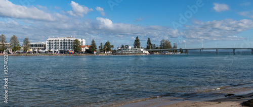 Panoramic waterside view of the lagoon with bridge and buildings © Merrillie