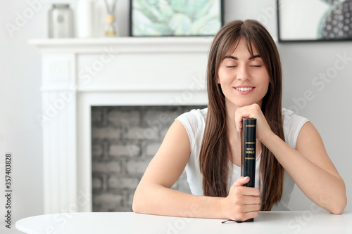 Young woman with Bible at home