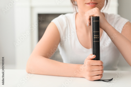 Young woman with Bible at home
