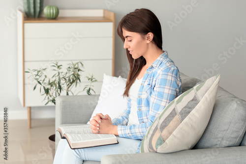 Young woman reading Bible a...