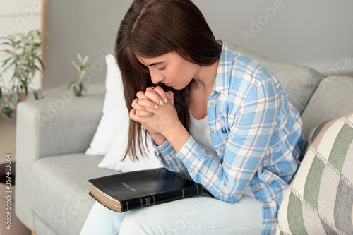 Young woman with Bible pray...