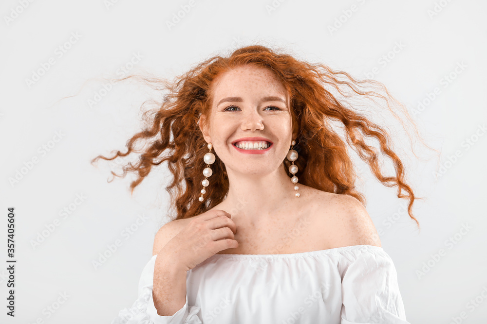 Portrait of beautiful redhead woman on light background Portrait of beautiful redhead woman on light background