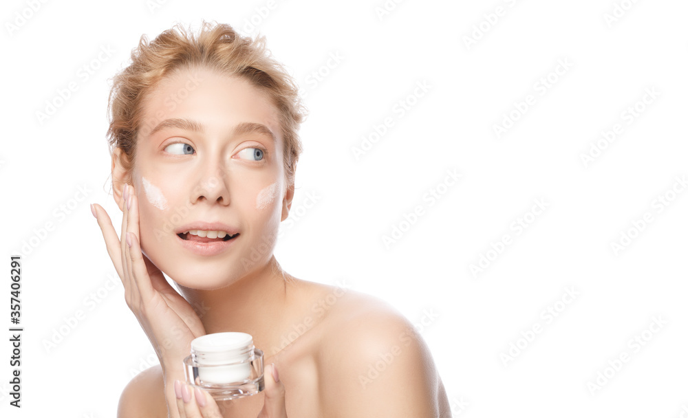 Banner of young beautiful woman with clear skin holding cosmetic jar and applying face cream, isolated on white background. Concept of female beauty treatment Banner of young beautiful woman with clear skin holding cosmetic jar and applying face cream, isolated on white background. Concept of female beauty treatment