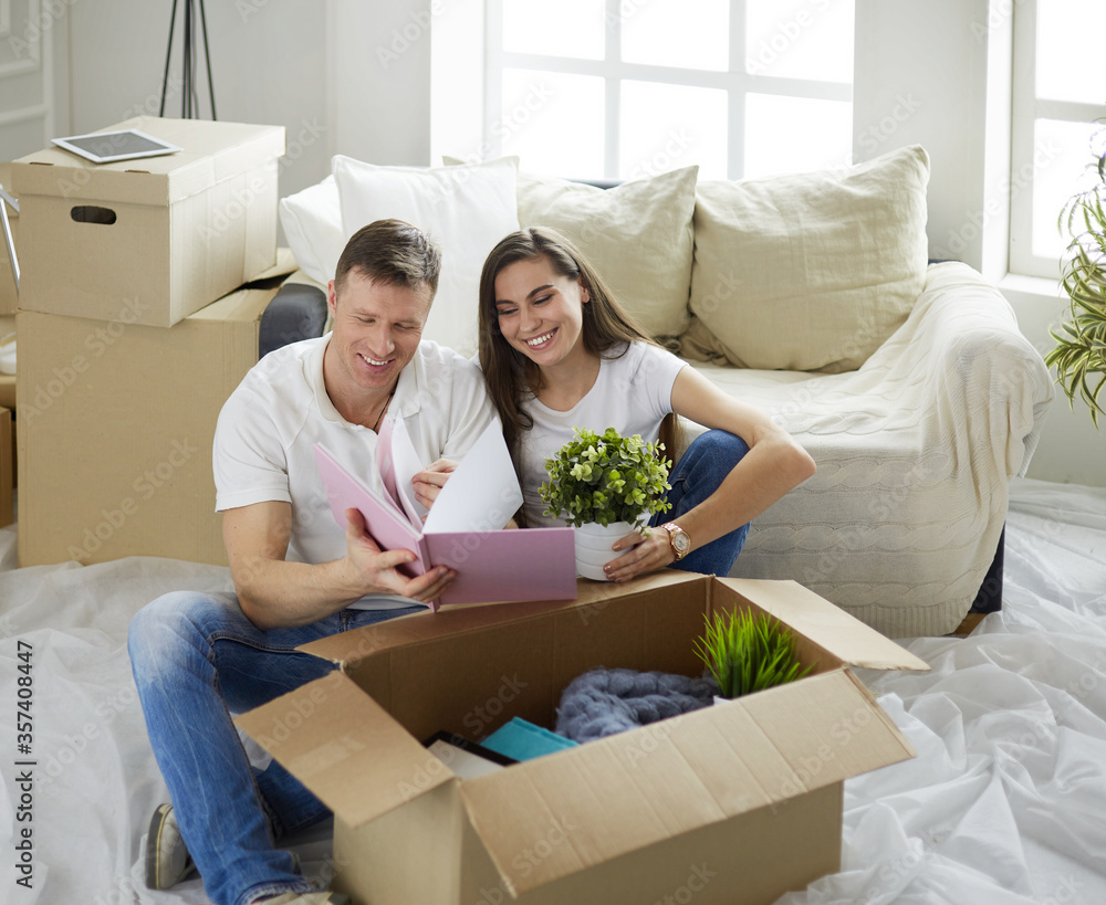 Cute couple unpacking cardboard boxes in their new home Cute couple unpacking cardboard boxes in their new home
